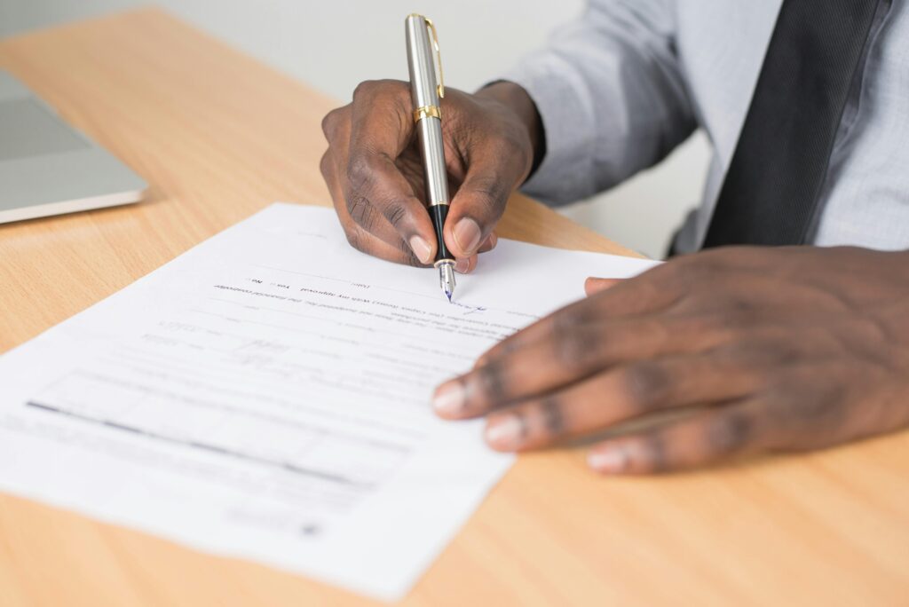 pexels-photo-955389-955389 Close-up of a businessman signing a contract at an office desk.